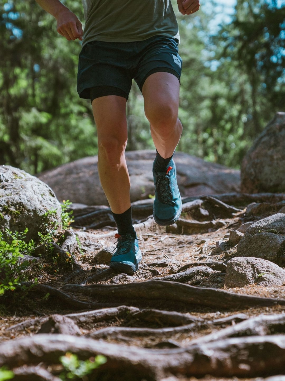KARHU trail running shoe on rocky terrain with roots